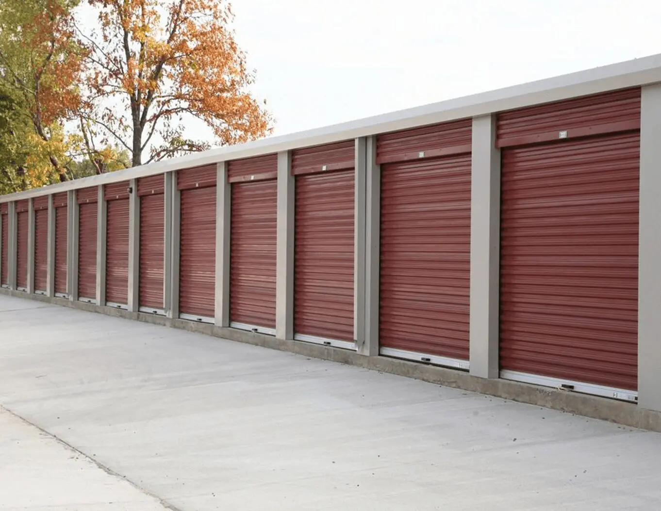 A row of red storage units on the side of a road.