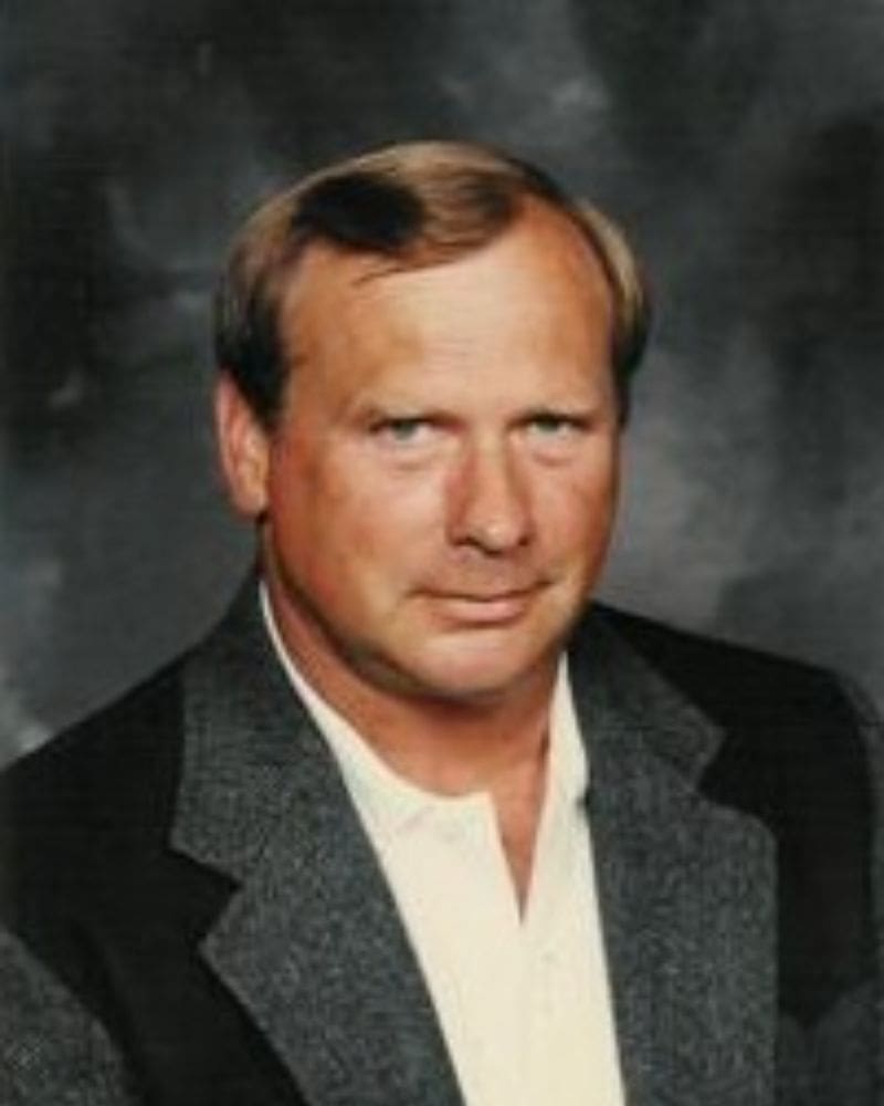 A man with a beard and mustache wearing a suit.