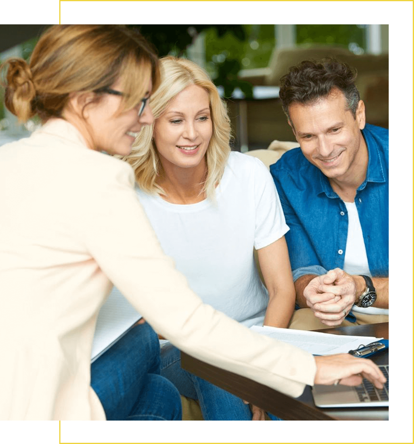 A woman is showing two men something on the computer.