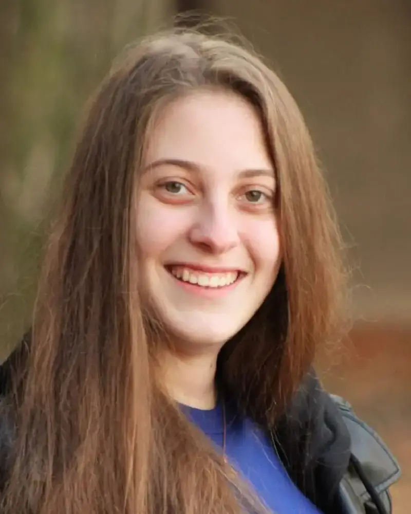 A woman with long hair smiles for the camera.