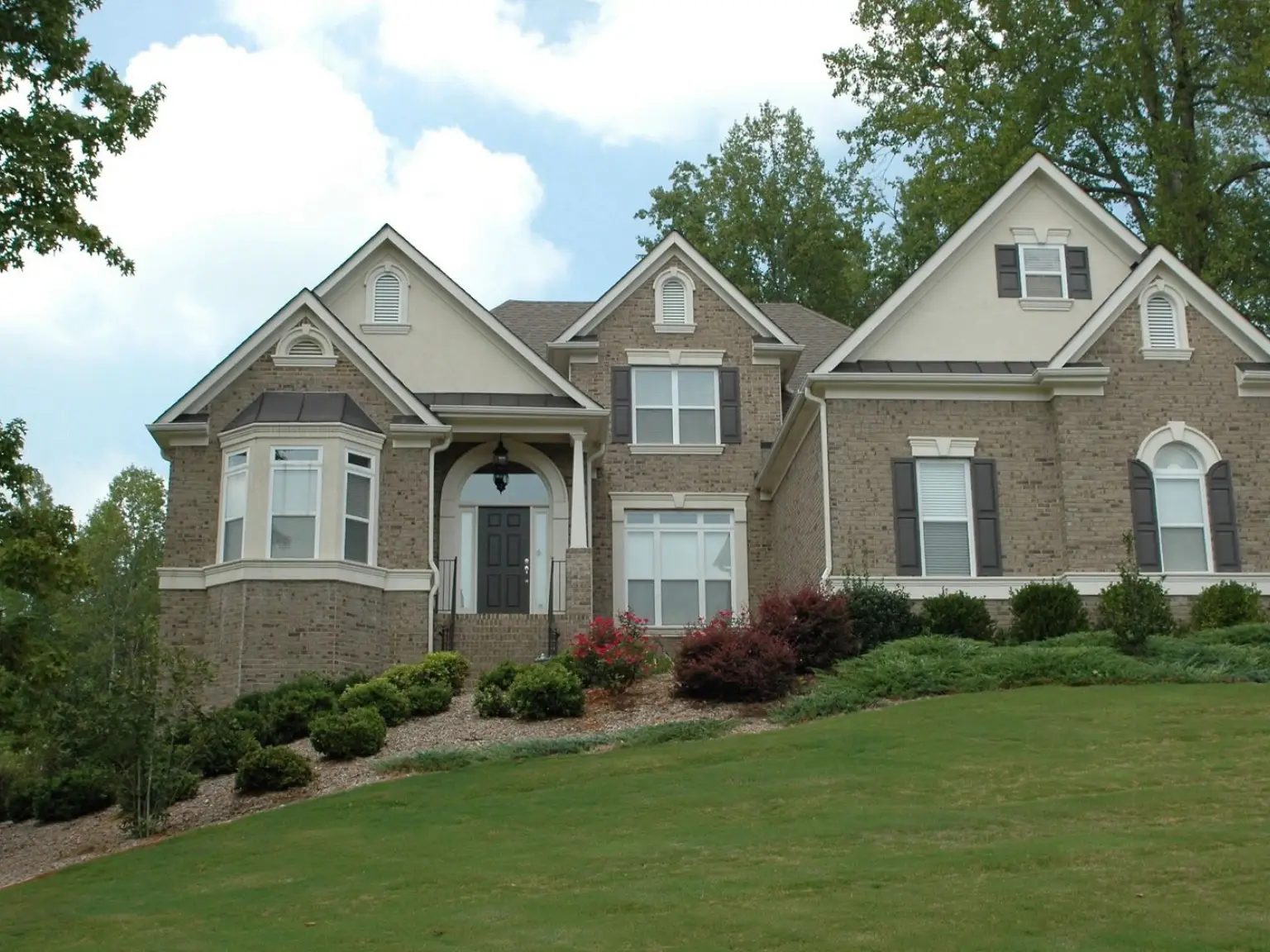 A large house with a grassy lawn in front of it.