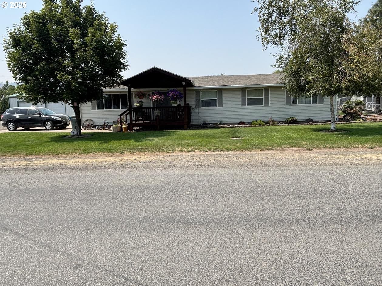 Single-story house with porch and landscaped yard.