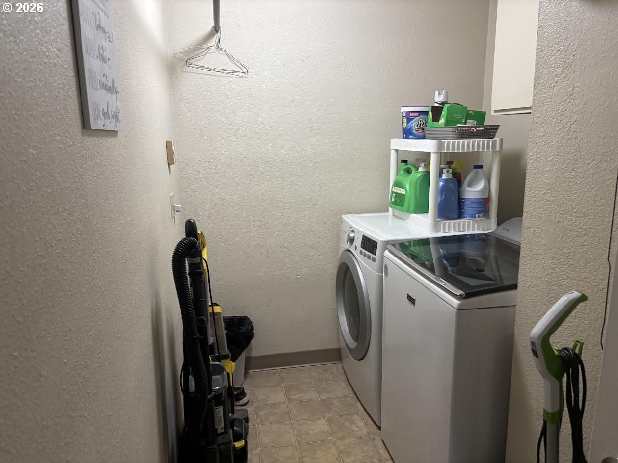 Laundry room with appliances and cleaning supplies.