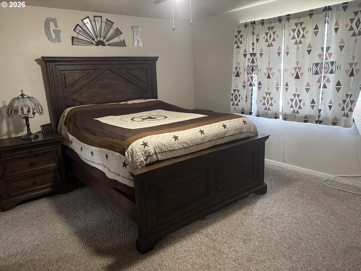 Rustic wooden bed with patterned quilt and lamp