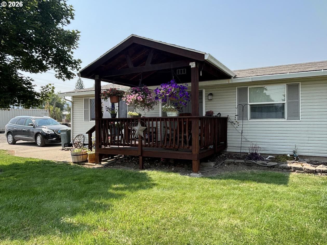 Front porch with flowers and grassy yard.