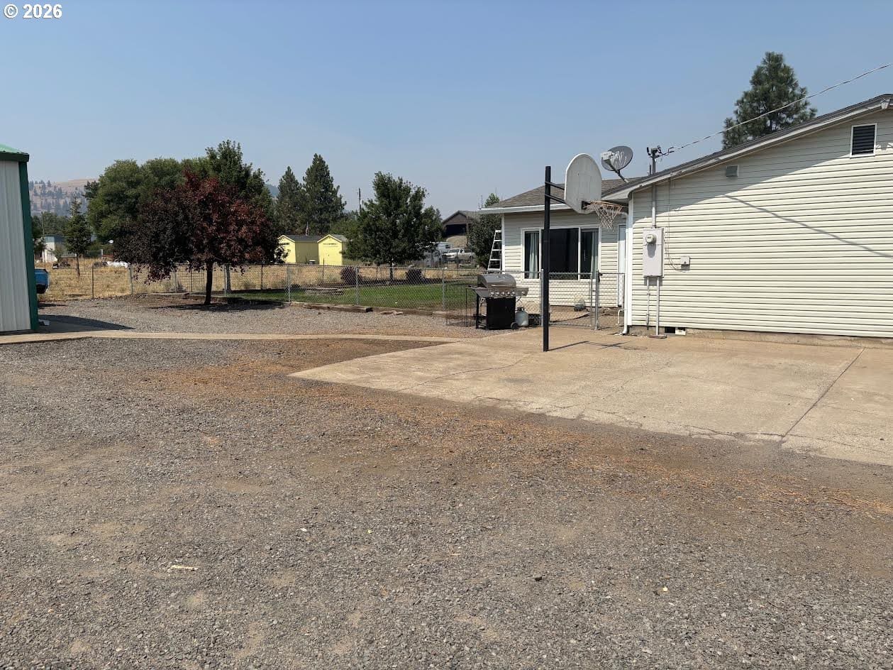 Gravel area with house and basketball hoop.