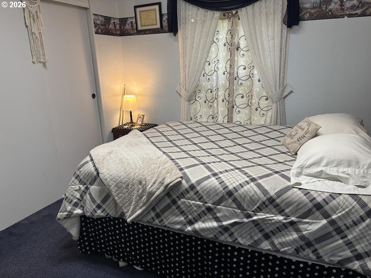 Cozy bedroom with patterned bedding and curtains.