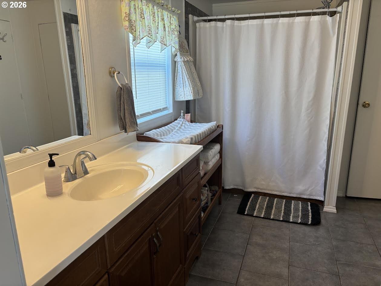 Bright bathroom with sink and shower curtain.