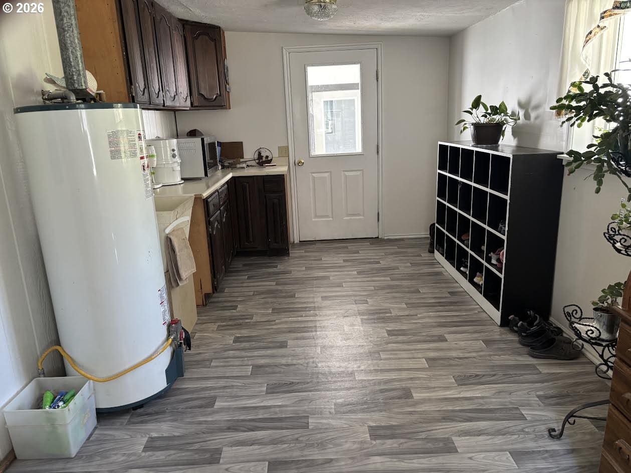 Light kitchen with wooden cabinets and flooring.