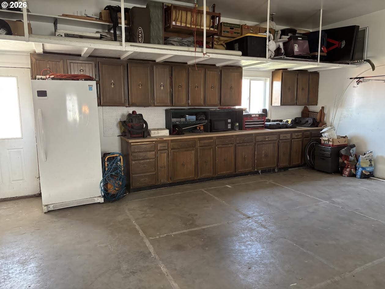 Spacious garage with cabinets and appliances visible.