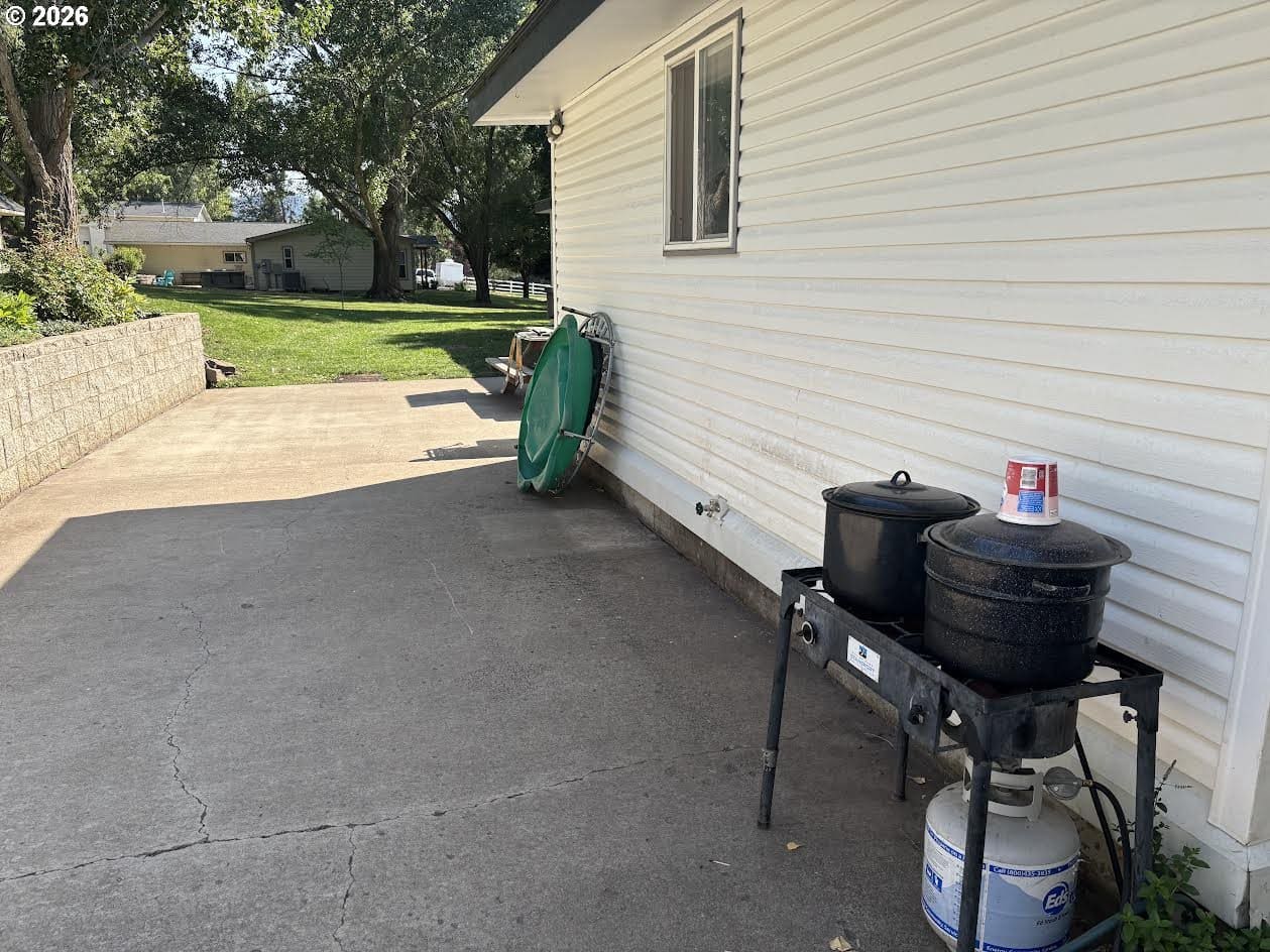 Outdoor space with cooking equipment and greenery.