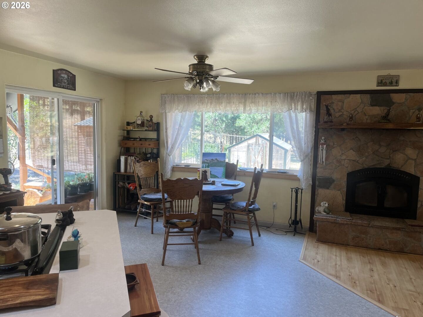 Cozy dining area with stone fireplace view.