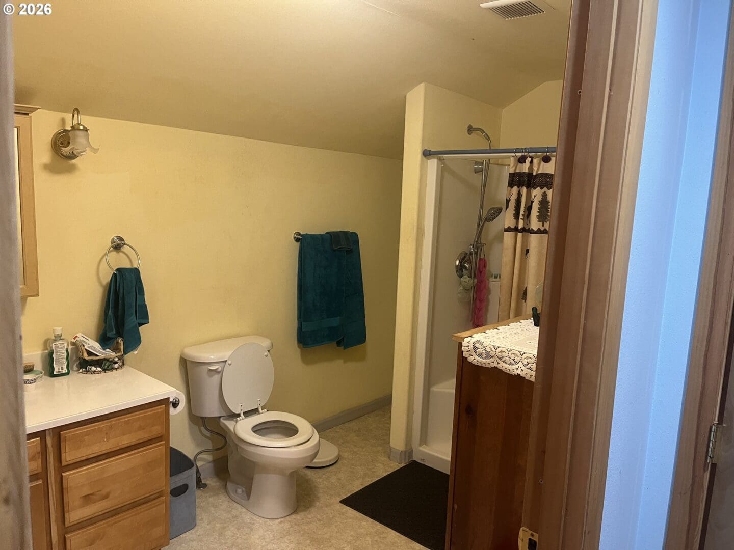 Small bathroom with light yellow walls and decor.