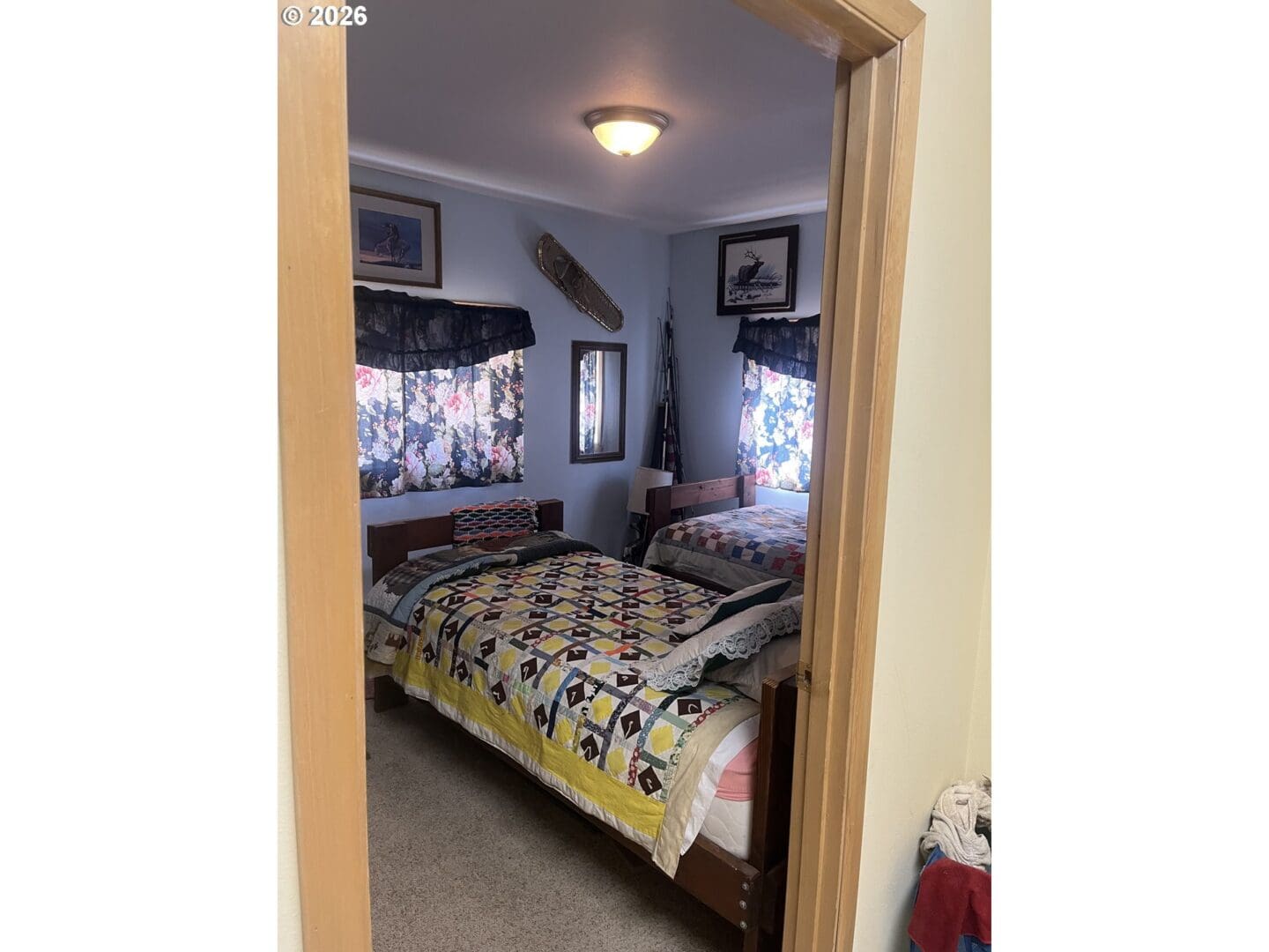 Cozy bedroom with patterned quilts and decor.