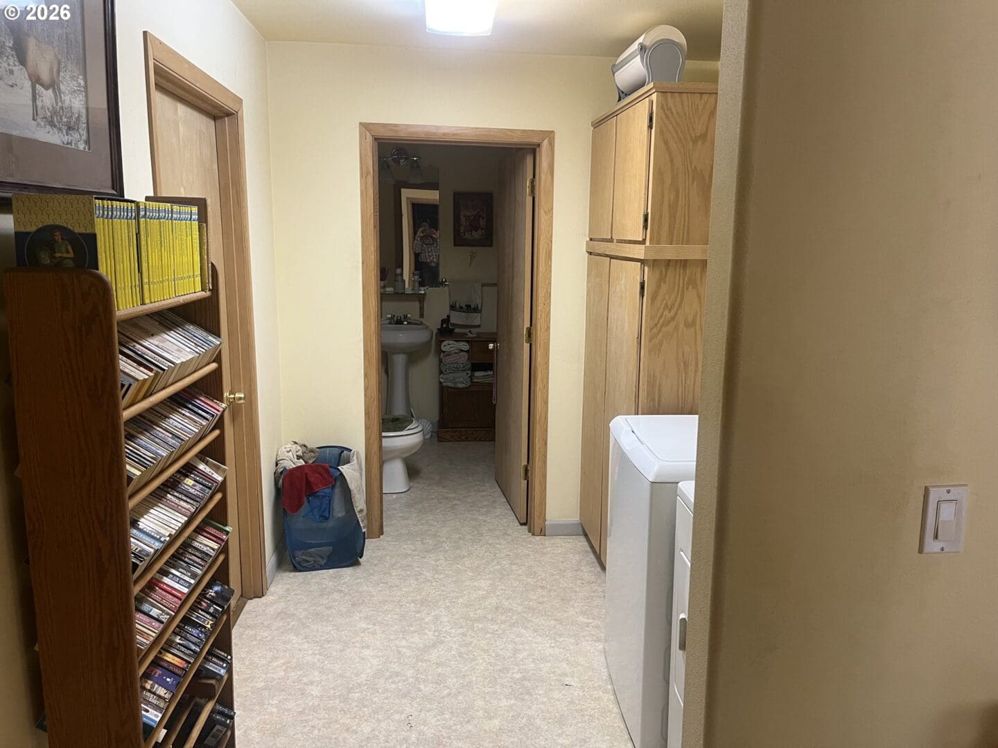 Narrow hallway with storage and laundry area.