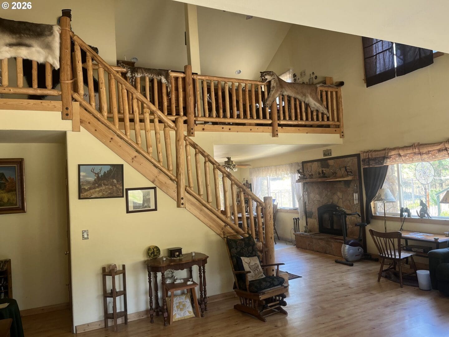 Spacious living area with wooden staircase and decor.