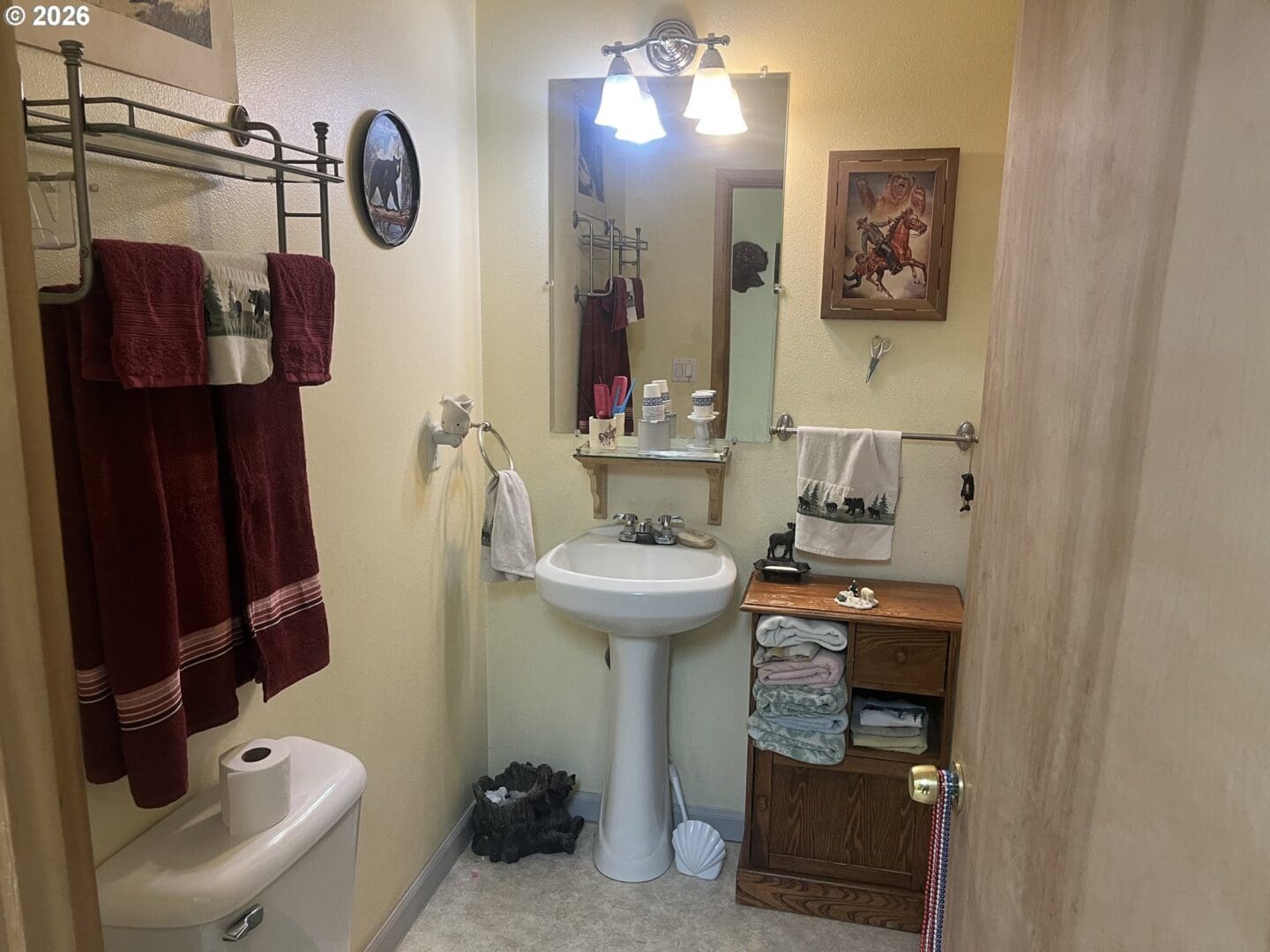 Cozy bathroom with towels and wooden accents.