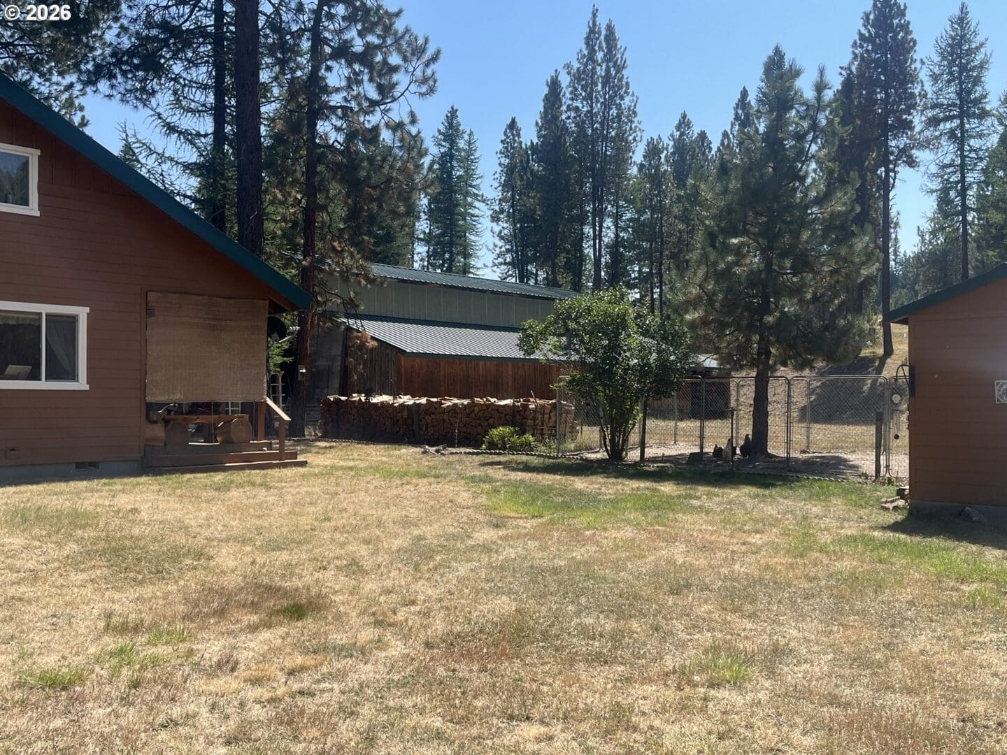 Wooden house with grassy yard and trees.