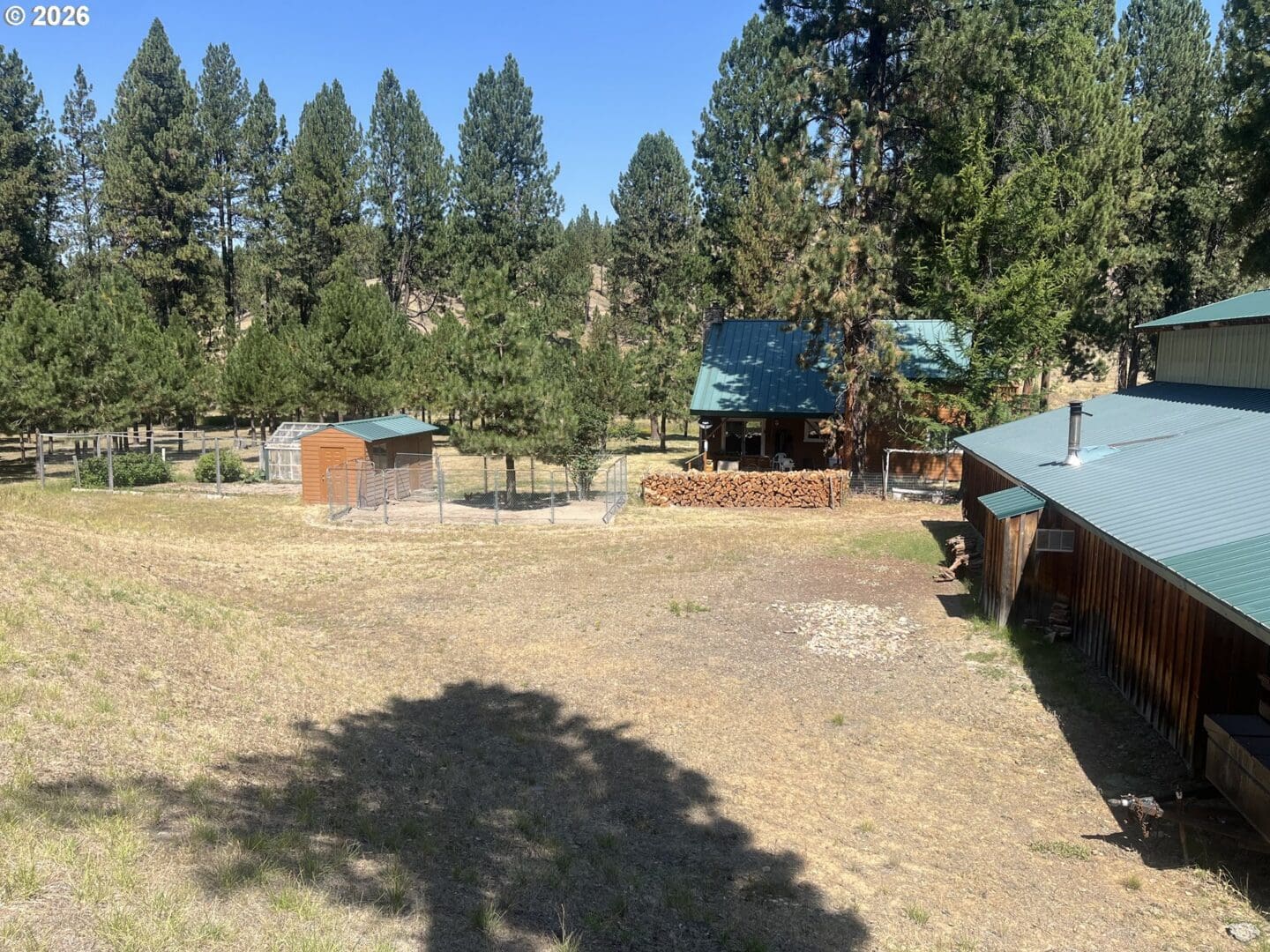 Rural landscape with wooden structures and trees.